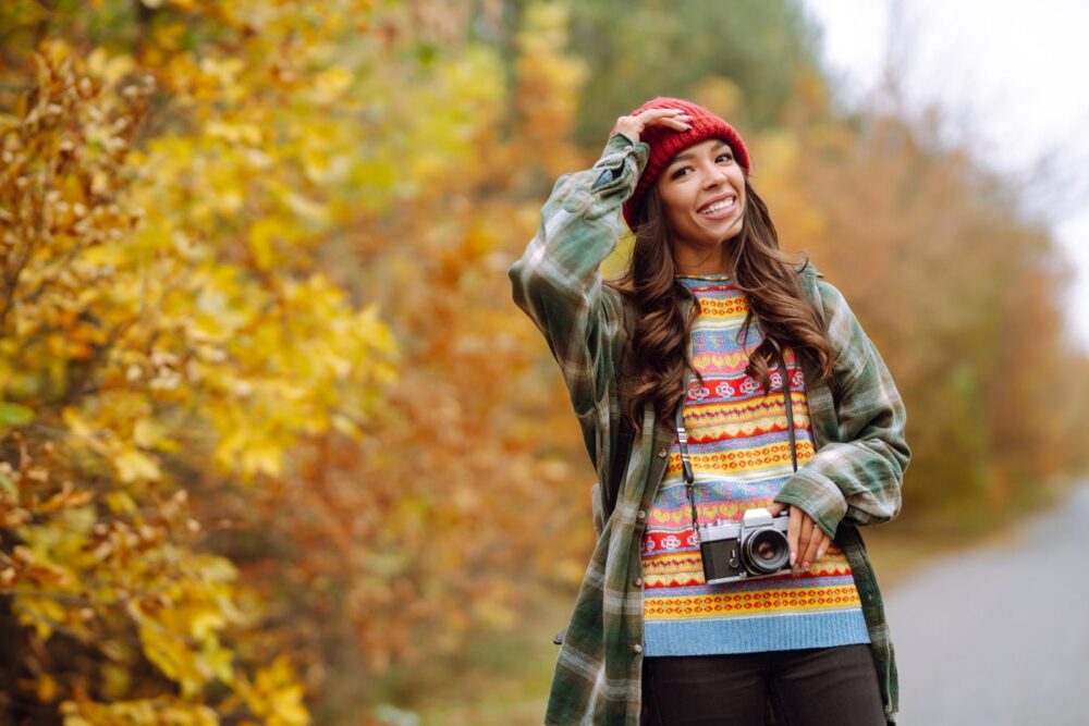 Skaista jauna sieviete tiek fotografēta ar retro kameru. Atpūta, relaksācija, ceļošana, dzīvesstila koncepcija